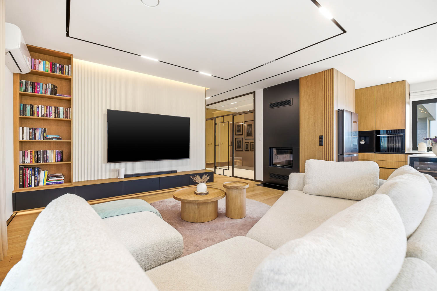 Profesjonalna sesja zdjęciowa nieruchomości we Wrocławiu – widok na nowoczesny salon z drewnianymi akcentami i białymi meblami wypoczynkowymi wykonana przez Grafoto.