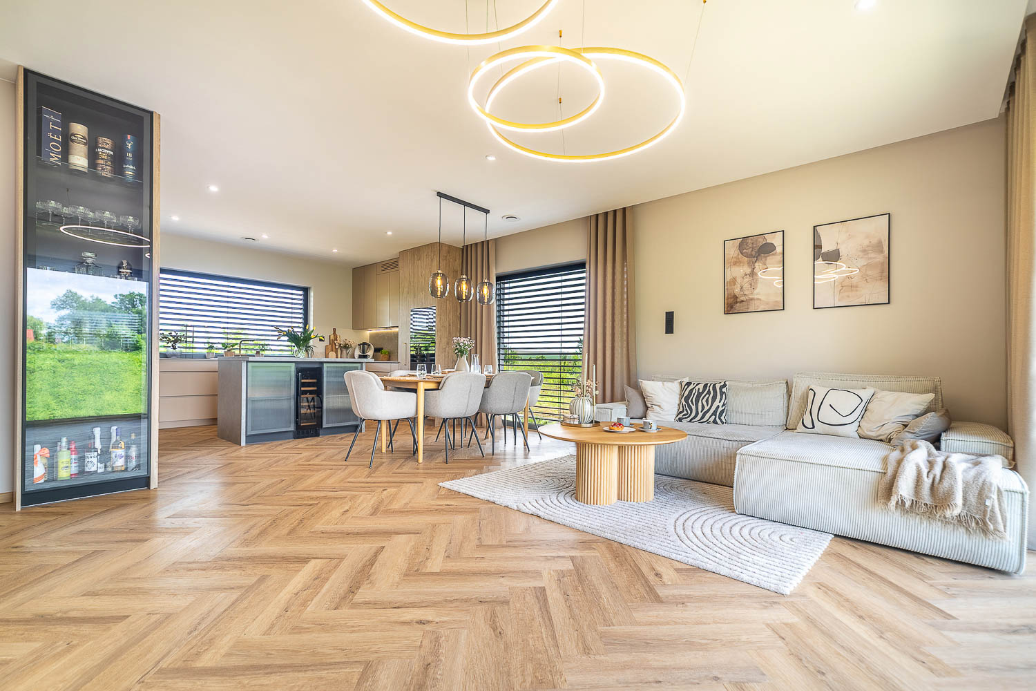 Jasna kuchnia z dębową zabudową, marmurową wyspą i przeszkloną witryną – realizacja Grafoto.